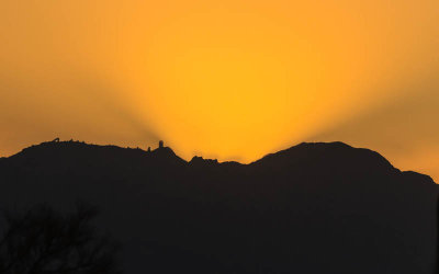 The sun casting a glow over Kitt Peak Observatory at sunset