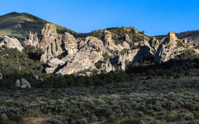 Direct sunlight reaches a large impressive granite formation in City of Rocks National Reserve