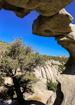 The Bread Loaves and other formations are framed by Window Arch in City of Rocks National Reserve