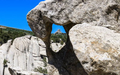 A small window frames a distant granite formation in City of Rocks National Reserve