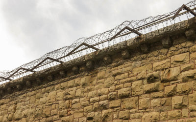 Barbed wire coiled on top of the prison wall in the Old Montana Prison