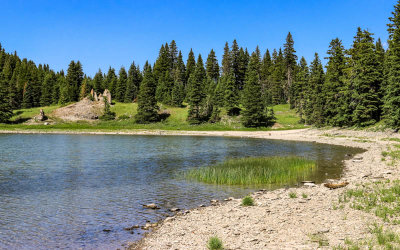 Rock formation and the northern shoreline at Crystal Lake in Lewis and Clark National Forest