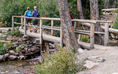 Bridge crossing along the Three Falls Trail in the foreground in Glacier National Park