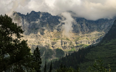 Clouds drop over a mountainous ridge in Glacier National Park