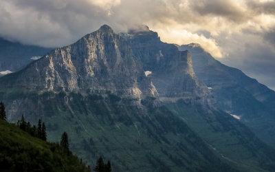 Sunlight touches Mount Oberlin and Mount Cannon in Glacier National Park