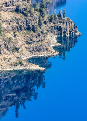 Vivid reflections in the calm, deep blue waters of Crater Lake in Crater Lake National Park
