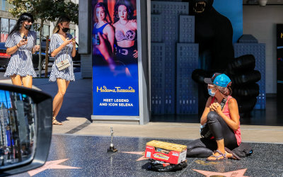 Hollywood twins pass a vendor on the Hollywood Walk of Fame on Hollywood Boulevard in Hollywood