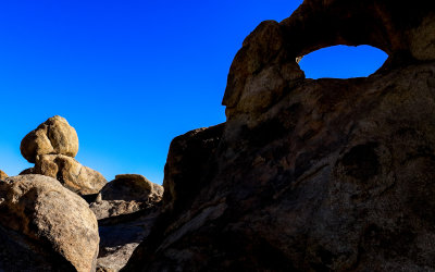 Large balanced boulder and a window arch in the Alabama Hills National Scenic Area