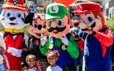 Cartoon and video game characters take a photo with children in Times Square