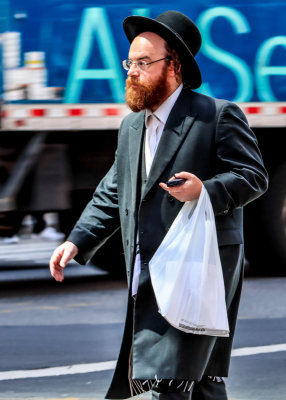 A Hasidic Jewish man strides through in Times Square