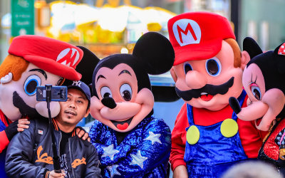 Cartoon characters take a selfie with a tourist in Times Square