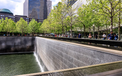 Water cascades over the edge of the South Pool on the 9/11 Memorial Grounds