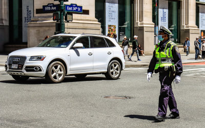 NYPD officer controls traffic at the intersection of Fifth Avenue and East 34th Street in New York City