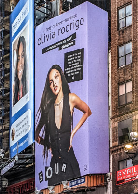 Olivia Rodrigo billboard (its brutal out here) in Times Square at Night