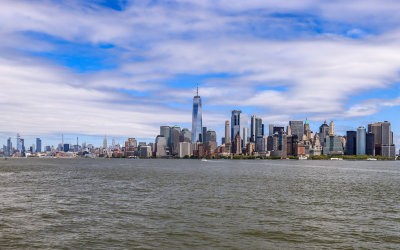 NYC Skyline under partly cloudy skies dominated by One World Trade Center