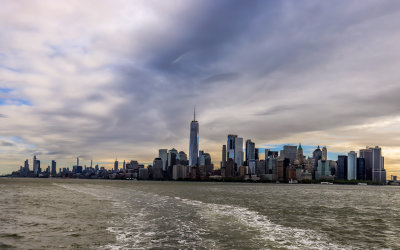 Wide view of Manhattan Island and the NYC Skyline under partly cloudy skies