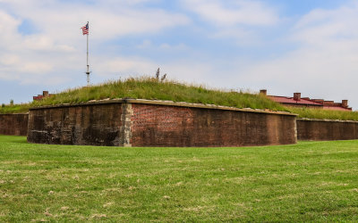 Closeup of fortress walls with the fifteen-star flag flying above in Fort McHenry NM and HS