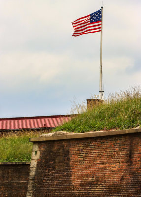 Closeup of fifteen-star flag flying above the fortress in Fort McHenry NM and HS
