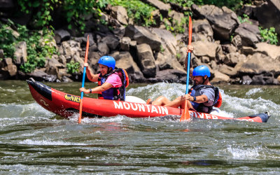 Tandem canoers take on the rapids at the Grandview Sandbar along the Glade Creek Road in New River Gorge National Park