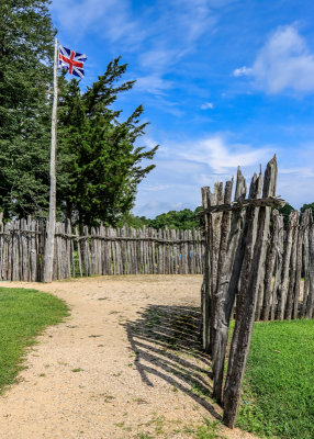 Flag of England flies over log wall placed on the original James Fort palisades (1607) at Jamestown in Colonial NHP