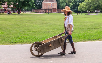 Period resident pushing a wheelbarrow in Colonial Williamsburg