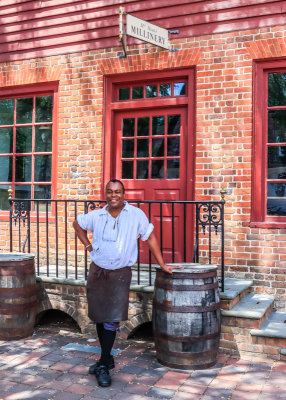 Leather worker in front of the Millinery along Duke of Gloucester Street in Colonial Williamsburg