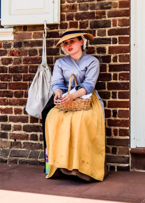 Young woman sitting in front of the Williamsburg Courthouse in Colonial Williamsburg