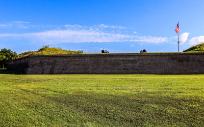 Cannons and the flag seen above the walls of Fort Moultrie in Fort Sumter National Monument