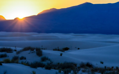 The sun sets behind the San Andres Mountains in White Sands National Park