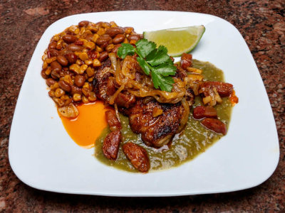 Pan seared chicken thigh with onion and chorizo and salsa verde. A side of chipotle spiced corn and bean medley.