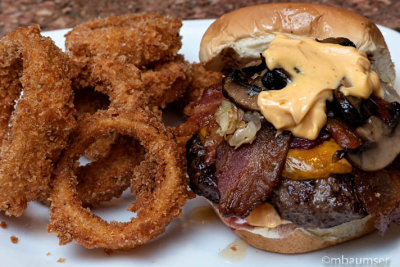 Bacon Cheddar Burger with Sautéed Onion and Mushroom and topped with a Mayo and Daves Insanity sauce.  Home made Onion Rings
