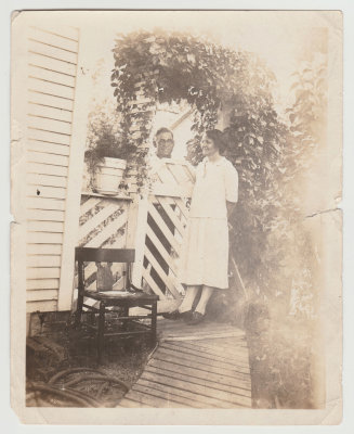 John and Clara Oberg by fence, being romantic