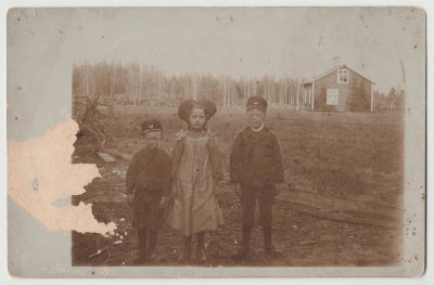 Postcard sent to Karin Lingblom in Lingbo, three unknown children with house and woods in background