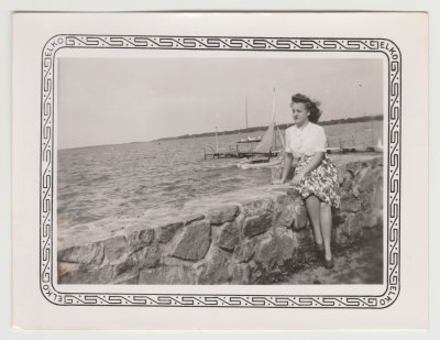 Helen Oberg sitting on rock wall by lake