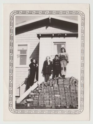 Clara Oberg with Kay, Chuck and Bob standing on woodpile