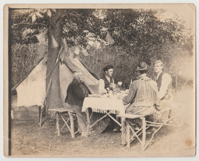 Family at picnic table by tent and flags (Arvid's family?)