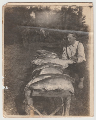 Young man with bench full of fish