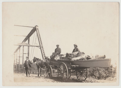 horse drawn wagon with men by bridge, in U.S.