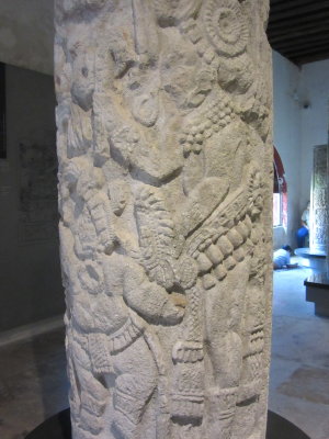 Column depicting Maya Court life - the ruler is watching a dwarf dance and two trumpeters play