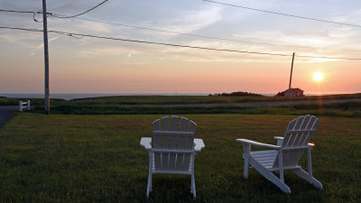 A pair of Adirondack chairs and a sunset