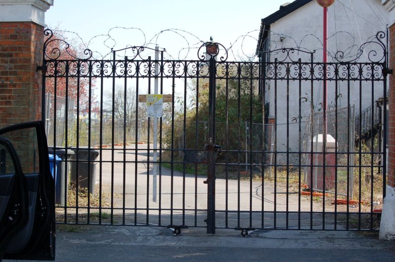 2010 - ERIC HOLMWOOD, JOINED MAY 1970, LOOKING THROUGH THE MAIN GATES.jpg