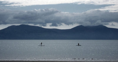 Paddleboarders and Welsh mountains from Newborough