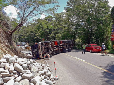 A 10-wheeler truck carrying GI pipes lies on its side after overturning in a winding portion of the Rosario-Pugo Road which leads to Marcos Highway. The accident, which happened shortly before 11:00 am of May 17, 2019, blocked the entire width of the road, rendering this route to Baguio City impassable to all motor vehicles. The unidentified driver was injured in the accident and rushed by good Samaritans to the nearest hospital. The truck, with license plate number RGA-687, is owned by DMAR Trucking Services in Baguio City. It is estimated that the road will remain impassable for many hours because a large crane is needed to lift and move the truck aside.

Photo by Romy Ocon, Email -  romy.ocon@yahoo.com
