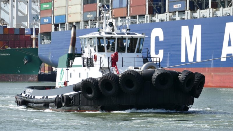 Tugboat Guiding Cargo Ship to Port