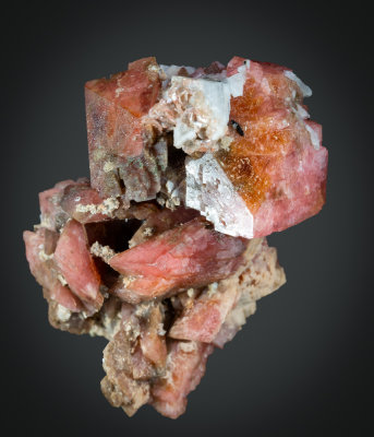 Rhodochrosite, sharp rhombohedral crystals in 4 cm cluster. Mont Saint Hilaire, Quebec, Canada.