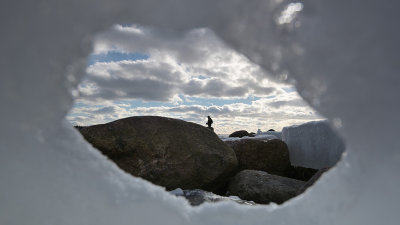 Fisherman through a hole in the ice