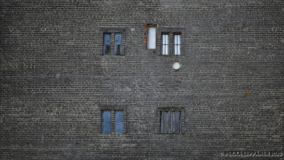 Five windows and a hole in a brick wall