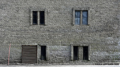 Seven (?) windows in a brick wall
