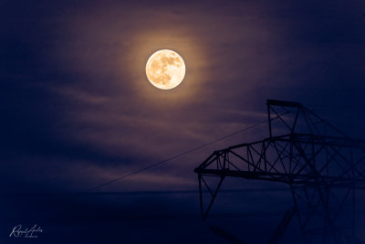 Moon over power line tower
