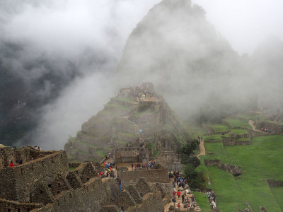 The Intihuatana comes into view as the fog lifts on Machu Picchu